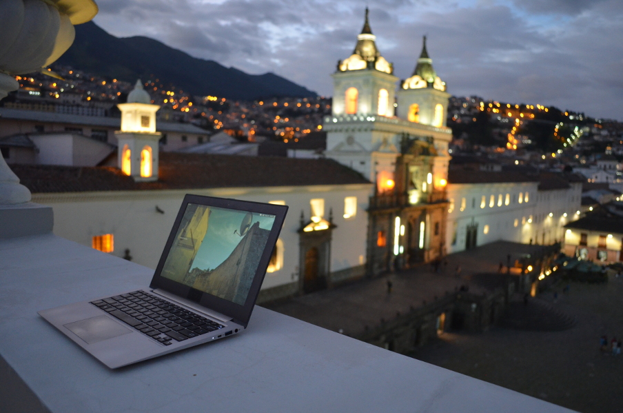My computer overlooking Plaza San Francisco in Quito, Ecuador, with a picture from the unMonastery as the desktop background.